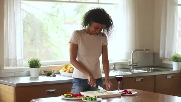 Happy young african woman vegetarian prepare salad meal at home - Metraje, vídeo