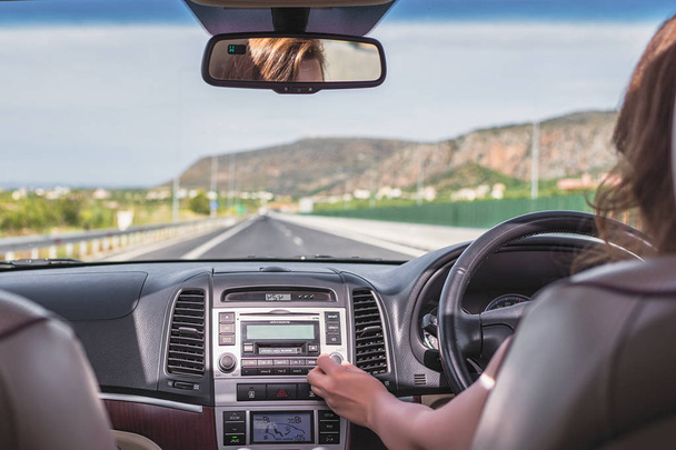Jeune femme conduit sur l'autoroute en Italie et en utilisant l'application de navigation GPS sur le téléphone mobile. Vue depuis le siège arrière de la voiture
 - Photo, image