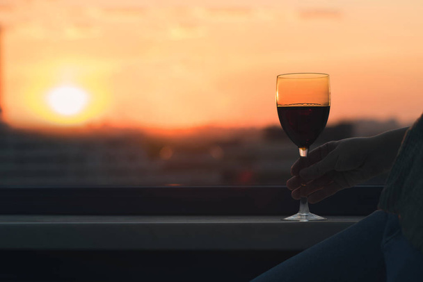 Silhouette of woman with glass of red wine  - Фото, зображення