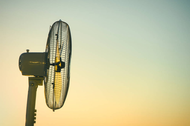 Electric fan ventilator against a background of a clear sunset sky. Concept - Foto, Imagem