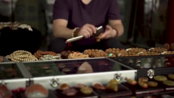 Ασιατικές υπαίθρια αγορά ένας άνθρωπος φτιάχνοντας παραδοσιακό κινέζικο βραχιόλι  - Πλάνα, βίντεο