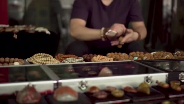 Mercatino delle pulci asiatico un uomo che fa braccialetto tradizionale cinese
  - Filmati, video