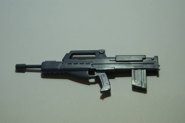 Nahaufnahme einer futuristischen Spielzeugpistole aus Plastik auf weißem Hintergrund - Foto, Bild