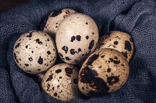 Quail eggs on blue natural textiles, a concept of healthy eating - 写真・画像