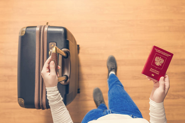 Top näkymä tyttö matkalaukku ja Venäjän passi kävely lentokentällä passi tarkastus
. - Valokuva, kuva