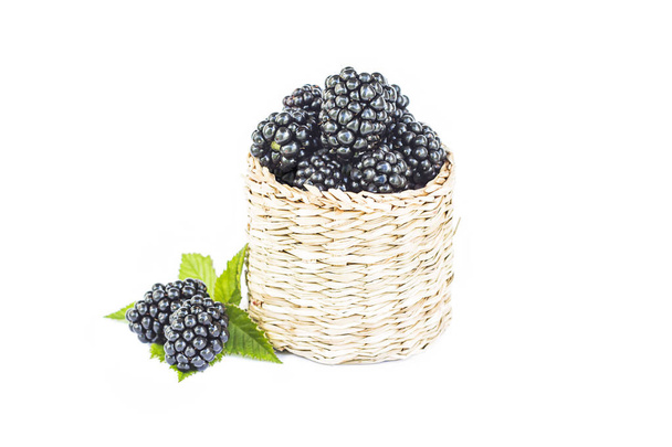 Ahşap hasır sepettaze böğürtlen, yaprak ile organik tatlı siyah berry, sağlıklı tatlı gıda, closeup, beyaz izole - Fotoğraf, Görsel