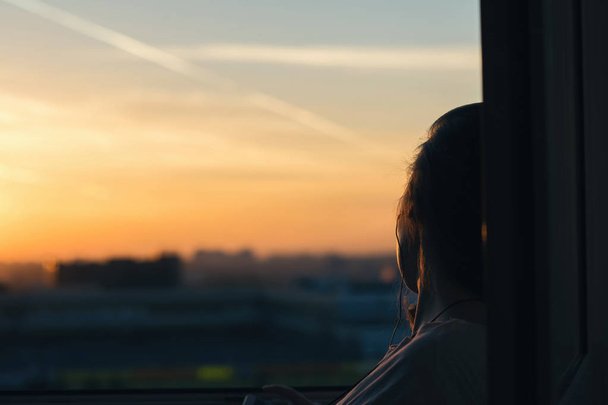 Girl in headphones listening to music in the city at sunset  - Φωτογραφία, εικόνα