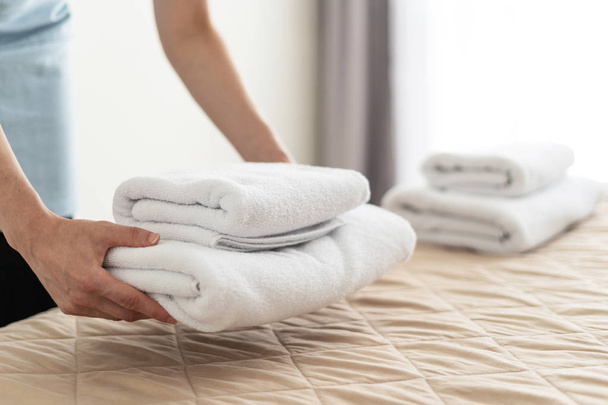 Mujer ama de casa sosteniendo toallas blancas en las manos
 - Foto, imagen