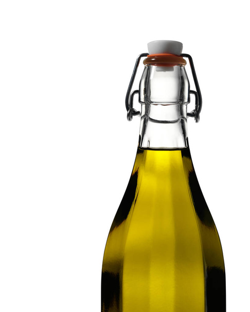 Lumière brille à travers l'huile d'olive dans une bouteille en verre clair sur blanc
 - Photo, image