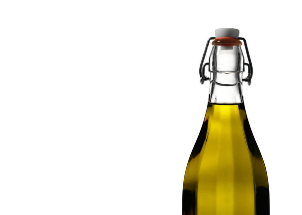 Lumière brille à travers l'huile d'olive dans une bouteille en verre clair sur blanc
 - Photo, image