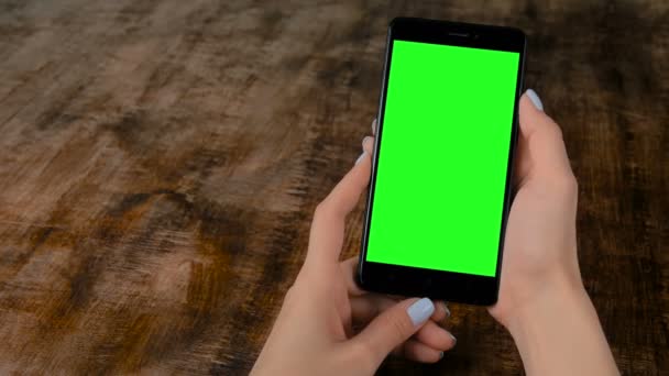 空白の緑色の画面を持つ黒いスマートフォンを保持している女性 - モックアップコンセプト - 映像、動画