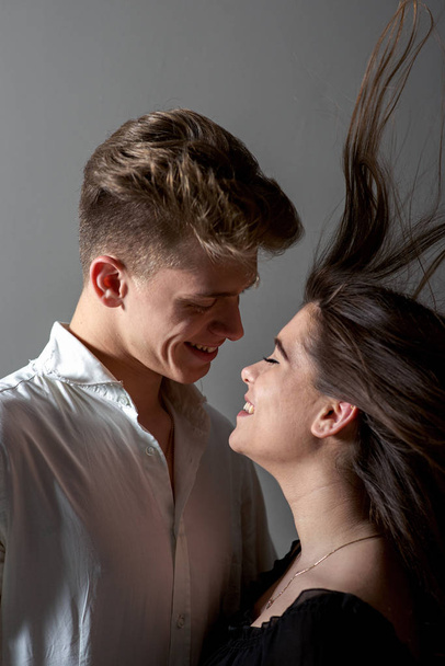 Jovem casal caucasiano sorrindo e olhando um para o outro
 - Foto, Imagem