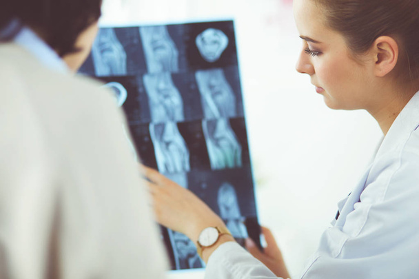 Young doctors studying X-ray images in clinic - Foto, Imagem