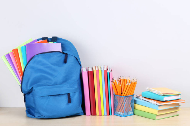 Backpack with school supplies on grey background - Zdjęcie, obraz