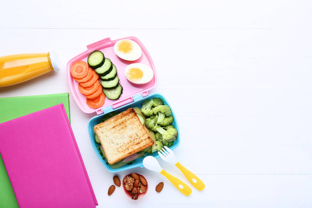 School lunch box with sandwich and books on white wooden table - Foto, Imagem
