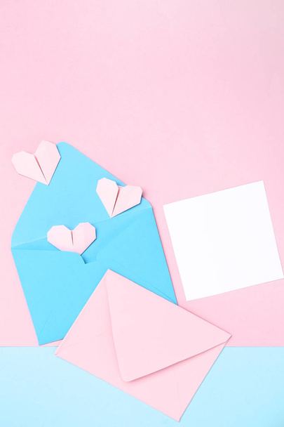 Paper envelopes with hearts and blank card on colorful backgroun - Photo, image
