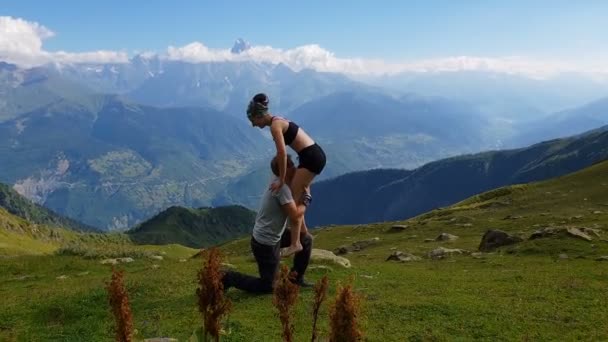 Young woman stepping on her mans knee in Georgian Mountains in summer in slo-mo - Footage, Video