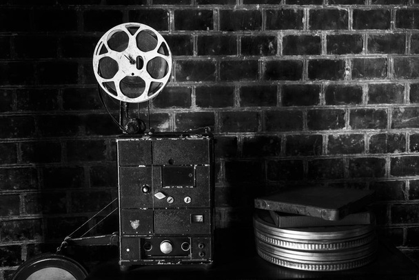 foto de un viejo proyector de cine en el fondo de la pared de ladrillo. Proyector de cine de estilo antiguo, bodegón, primer plano
. - Foto, Imagen