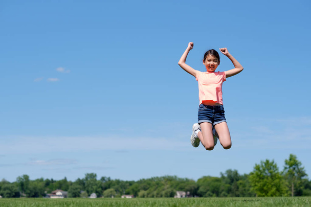 Menina adolescente asiática feliz pulando alto no ar
 - Foto, Imagem