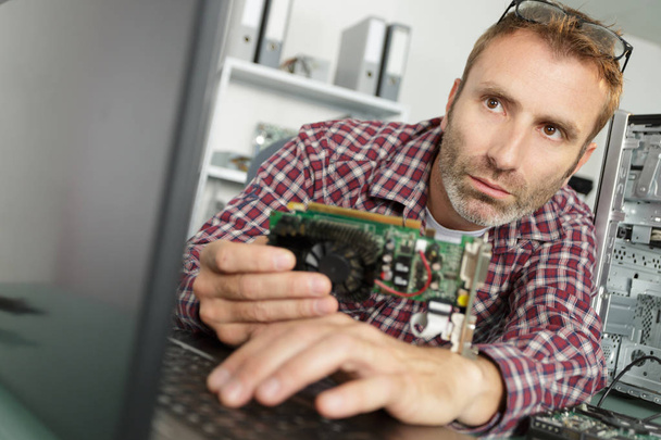 computer technician holding computer component - Photo, Image