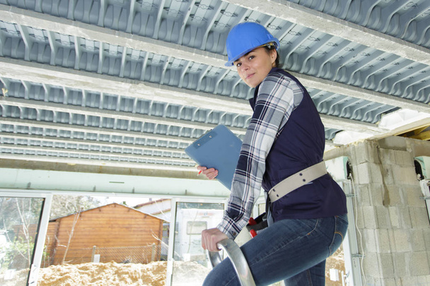 happy working woman in builder uniform indoor - Photo, Image