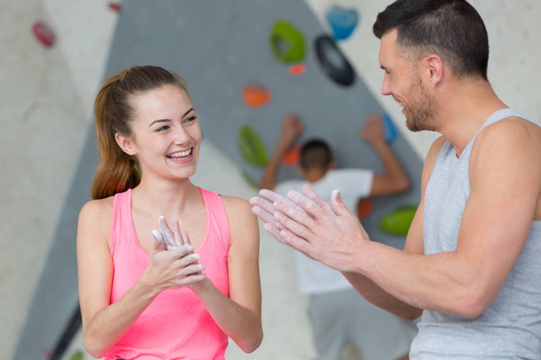 wall climbing couple putting chalk on hands - Photo, image