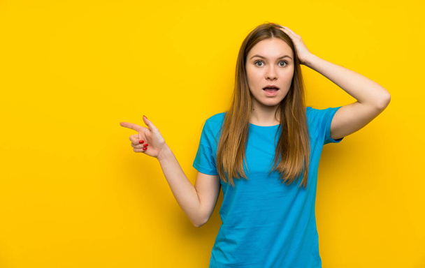Молода жінка з синьою сорочкою спрямовує палець на бік і представляє продукт
 - Фото, зображення
