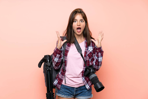 Young photographer girl over isolated pink background with surprise facial expression - Φωτογραφία, εικόνα