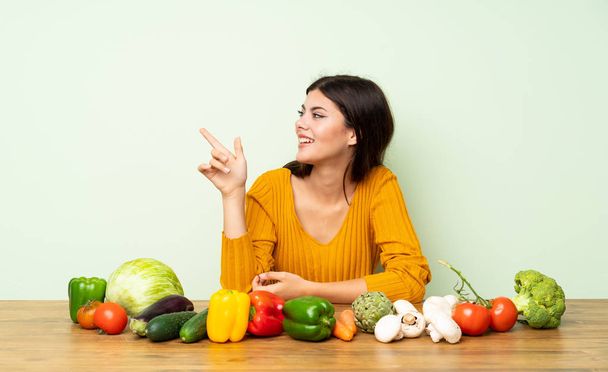 Дівчина-підліток з багатьма овочами, спрямованими пальцем в сторону
 - Фото, зображення