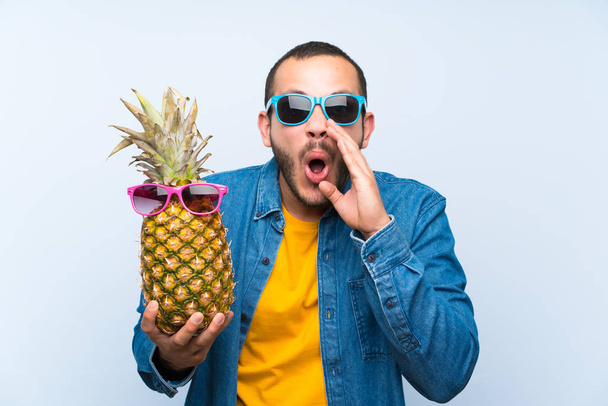 Kolumbiai ember, aki rendelkezik egy ananász napszemüveg kiabálva a szája tárva-nyitva - Fotó, kép