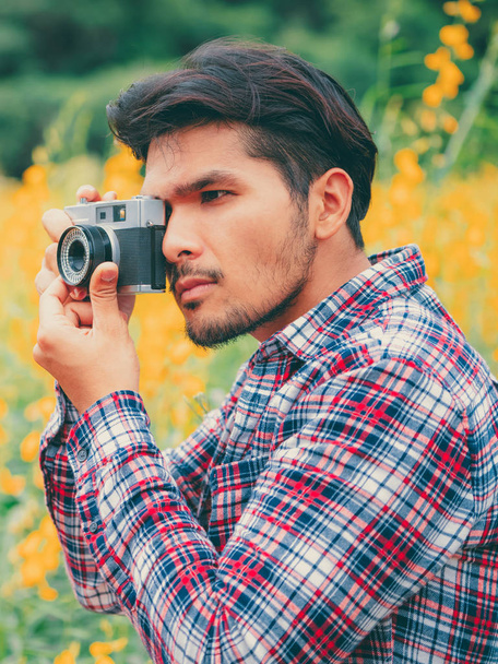 Fiatal csípő férfi fotózás a retro kamera. - Fotó, kép