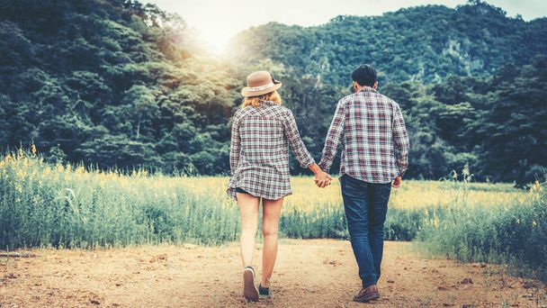 幸せなカップルは丘の上をロマンチックな散歩を取る. - 写真・画像