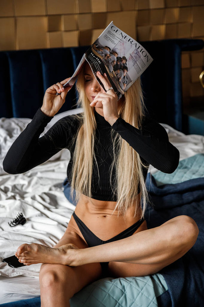 Beautiful fitness blonde posing in room interior. Studio shot of sexy model at luxury apartments  - Фото, изображение