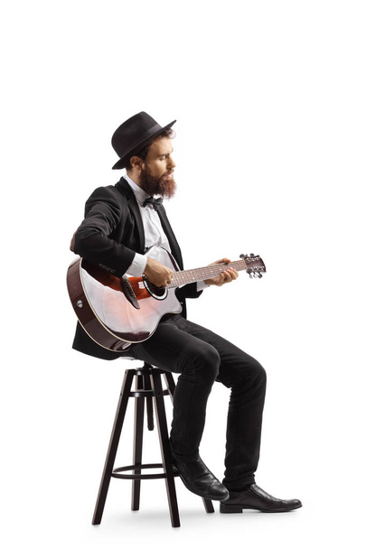 Man sitting on a chair and playing an acoustic guitar - Fotó, kép
