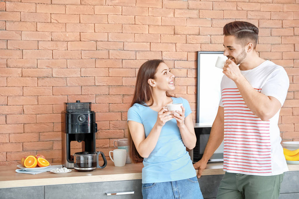 Jovem casal beber café quente na cozinha
 - Foto, Imagem