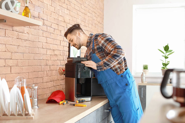 hombre reparación de la máquina de café en la cocina - Foto, imagen