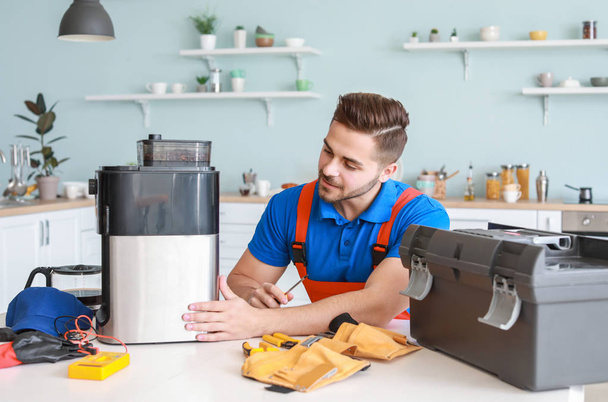 Mann repariert Kaffeemaschine in Küche - Foto, Bild