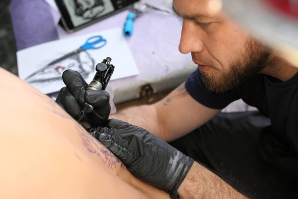 Профессиональный художник делает татуировку в салоне - Фото, изображение
