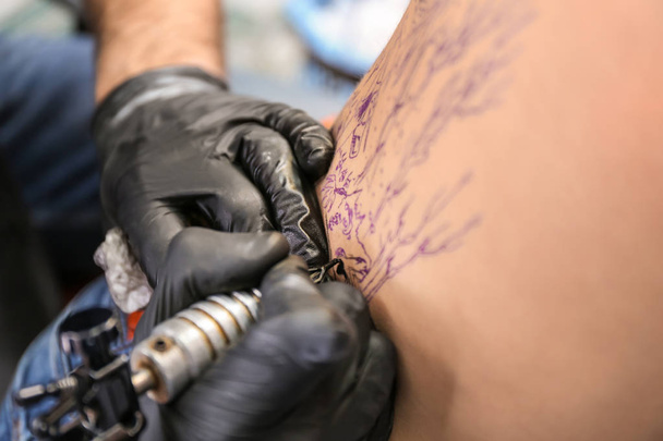 Professional artist making tattoo in salon, closeup - Valokuva, kuva