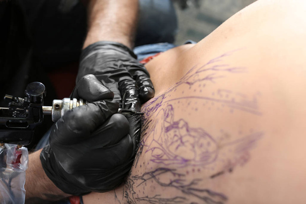 Szakmai artist making tattoo in salon, closeup - Fotó, kép