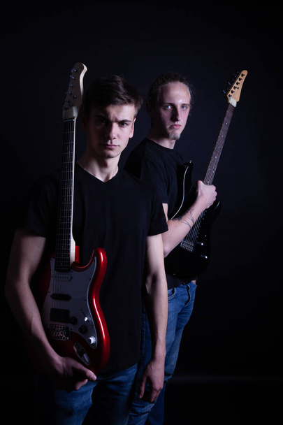 Rock band bestaande uit twee jonge blanke volwassenen die poseren in de - Foto, afbeelding