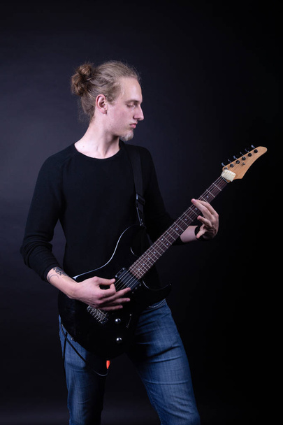 Fiatal kaukázusi felnőtt gitározni a stúdióban - Fotó, kép