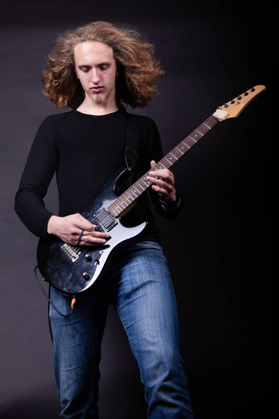 Jeune adulte caucasien jouant de la guitare en studio
 - Photo, image