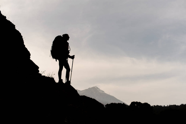 Silueta de mujer excursionista posando en la montaña
 - Foto, imagen