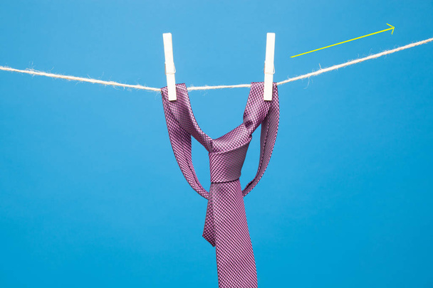 Tie with classic knot, hung on a rope and fastened by wooden clothespins to hang clothes - Foto, immagini