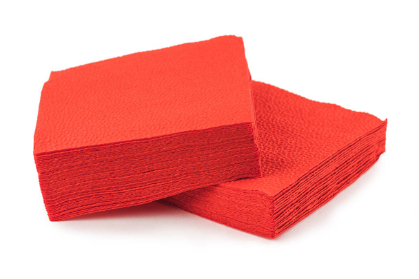 Stapel sauberer roter Papierservietten auf weißem Hintergrund. - Foto, Bild