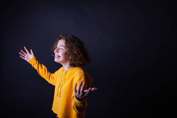 Young caucasian highschool girl in yellow hoodie posing in the studio - Fotografie, Obrázek