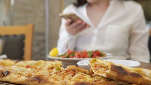 Tradycyjny azerski obiad z Khachapuri i kobieta z telefonem w rozmycie. - Materiał filmowy, wideo