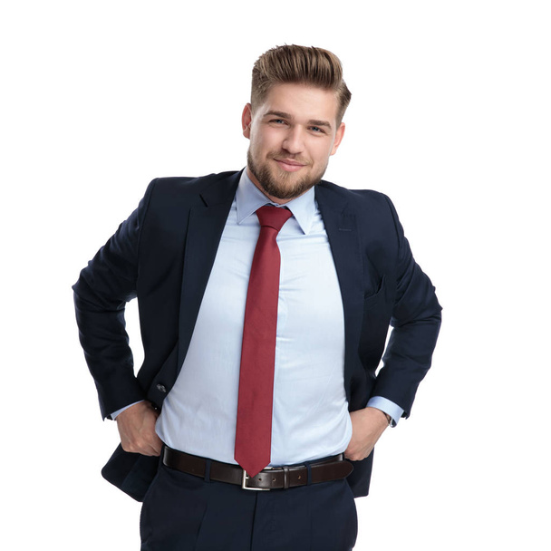 Cheerful businessman pulling his pants and smiling  - Foto, afbeelding