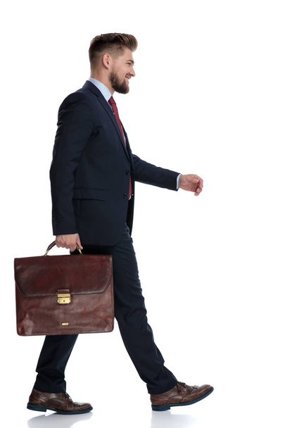 ブリーフケースを持って歩く自信のあるビジネスマンの側面図 - 写真・画像